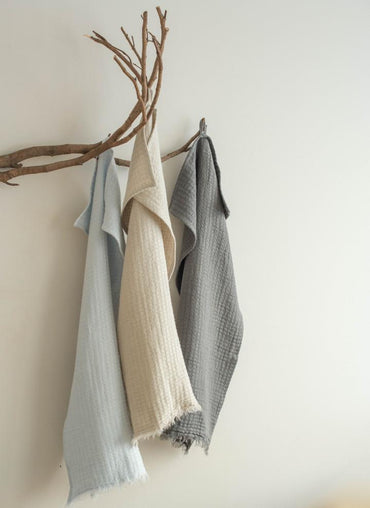 Hampton Linen tea towel in neutral tones hanging on a wooden branch