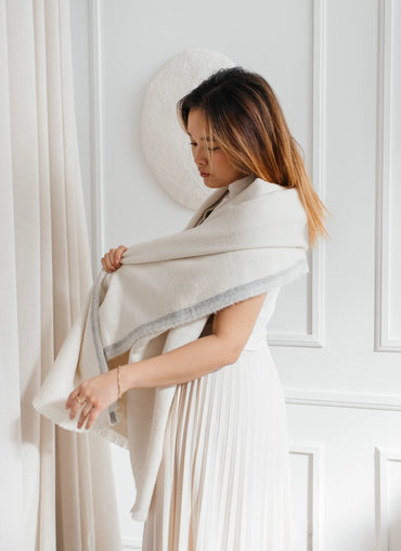 Woman wearing Jutland Baby Alpaca Throw – soft and warm.
