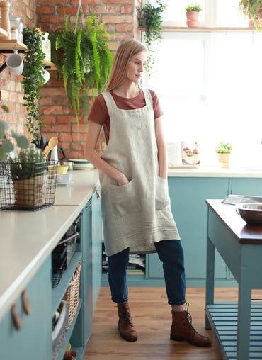 Woman wearing a linen apron in a cozy kitchen
