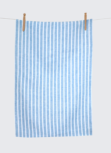 Blue and white striped towel hanging on a clothesline against a light gray background