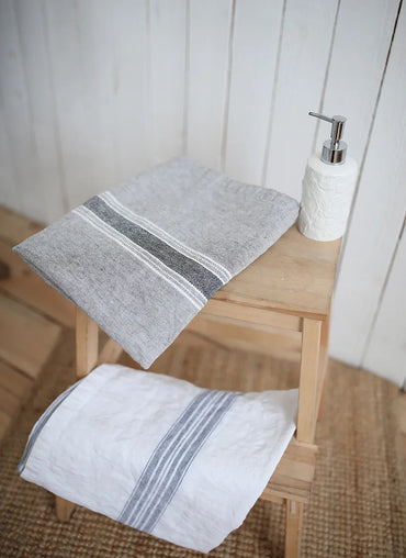 Casa Linen Guest Towels in natural and grey tones, neatly folded on a wooden stool