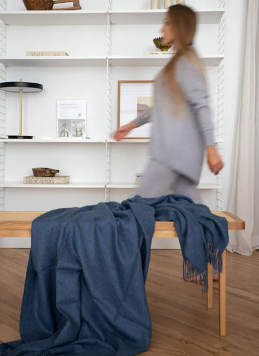 Paris Baby Alpaca Throw in navy blue draped over a wooden bench, elegant and cozy