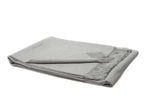 Paris Baby Alpaca Throw in light gray, neatly folded to showcase its soft texture and fine detailing.